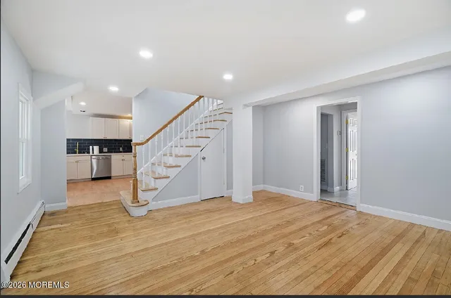 a view of a livingroom with wooden floor and stairs