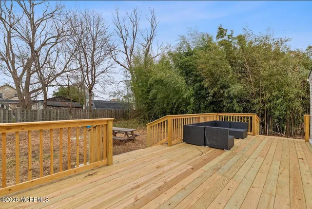 a view of a wooden deck and trees in the background