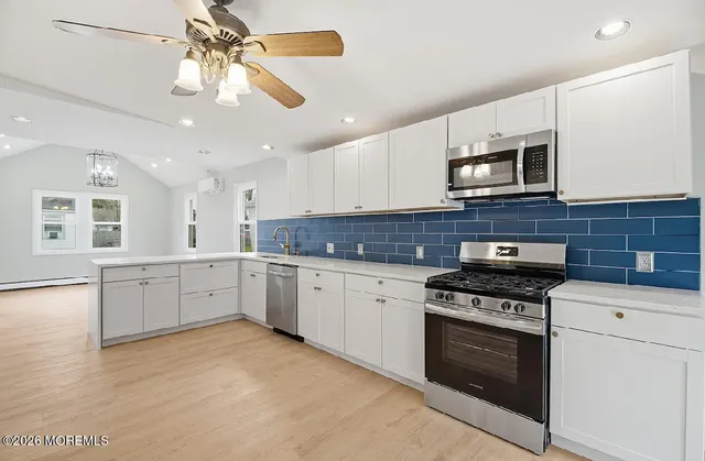 a kitchen with stainless steel appliances granite countertop a stove sink microwave and cabinets