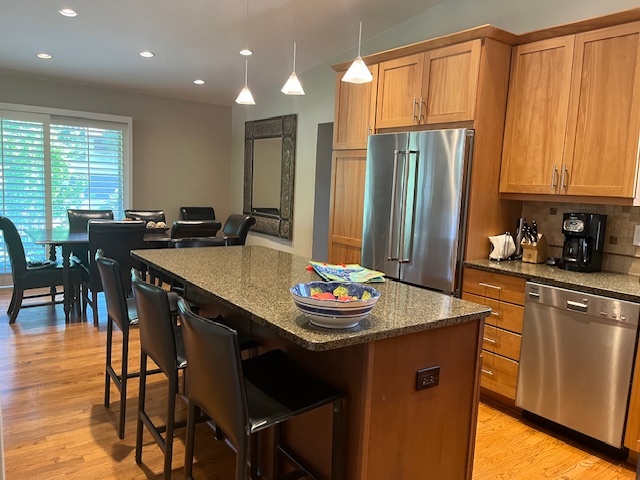 810 Virginia Road Highland Park, IL 60035 - Photo 3 of 14 a kitchen with stainless steel appliances granite countertop a table chairs and a refrigerator