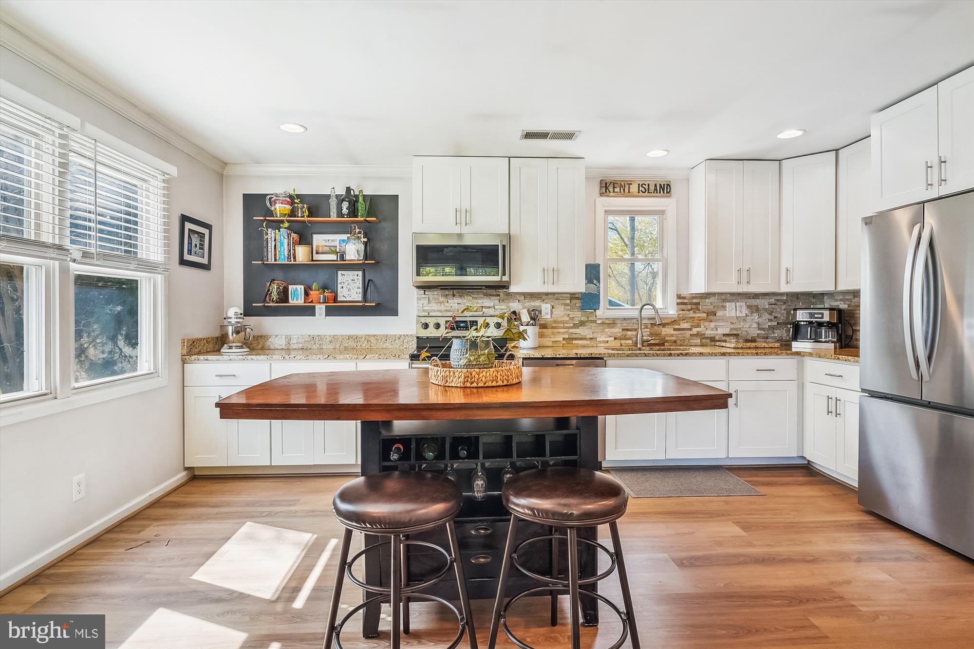 204 McKay Road Stevensville, MD 21666 - Photo 11 of 31 a kitchen with stainless steel appliances granite countertop a stove a sink a refrigerator a microwave and white cabinets with wooden floor