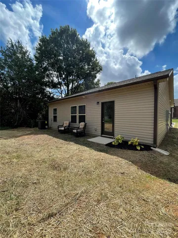 a front view of house with yard and trees in the background
