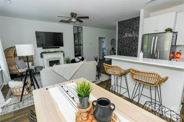 a living room with furniture a flat screen tv and a refrigerator
