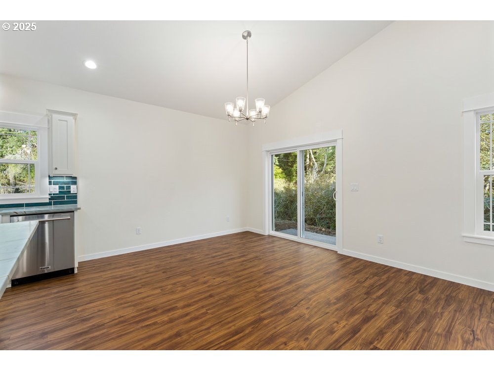 1241 Lighthouse Lane Brookings, OR 97415 - Photo 14 of 32 a view of an empty room with wooden floor and a window