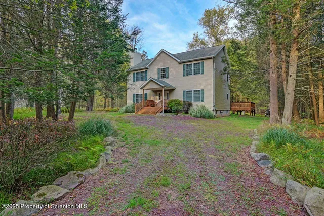 a front view of a house with a yard and trees