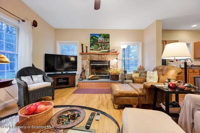 a view of a dining room and livingroom with furniture wooden floor a chandelier