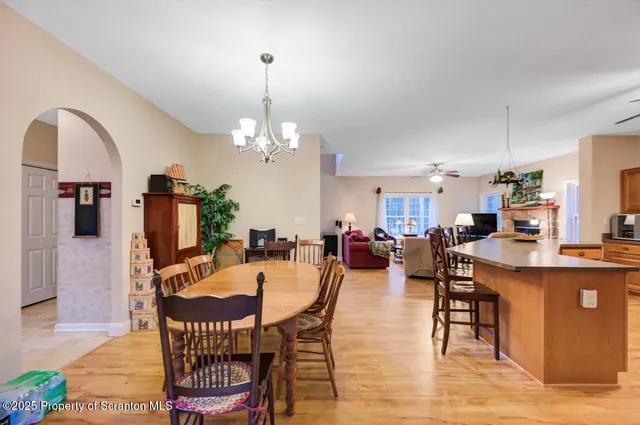 a kitchen with stainless steel appliances granite countertop a refrigerator a stove top oven a sink dishwasher and white cabinets with wooden floor