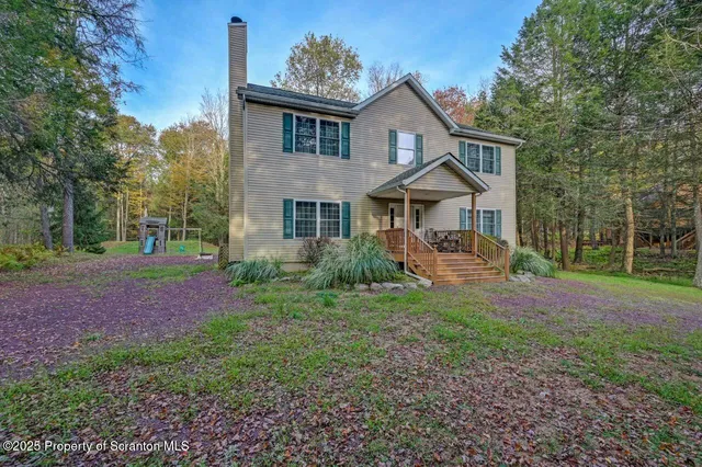 a front view of a house with yard and green space
