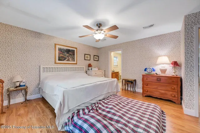 a view of empty room with wooden floor and fence