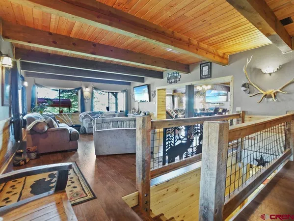 a dining room with wooden floor and large glass windows