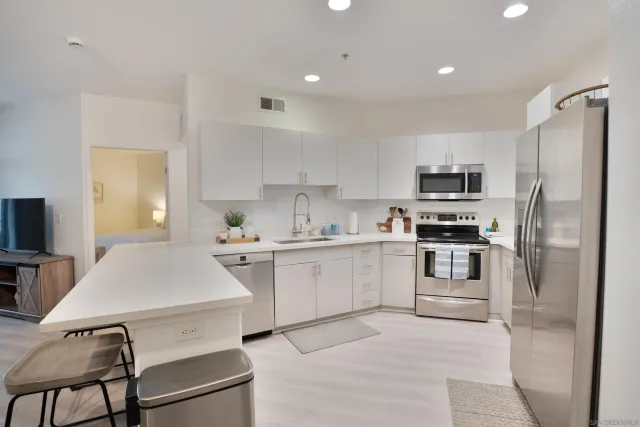a kitchen with white cabinets stainless steel appliances and sink
