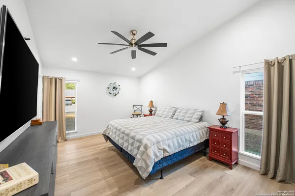 a bedroom with a large bed and a chandelier