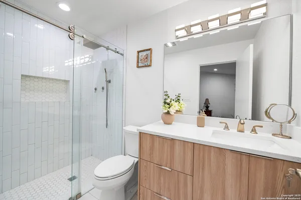 a bathroom with a granite countertop sink toilet and shower