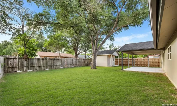 a view of a backyard with a small cabin and wooden fence
