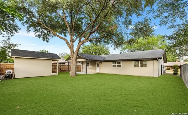a front view of house with yard and trees all around