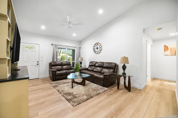 a living room with furniture and a wooden floor