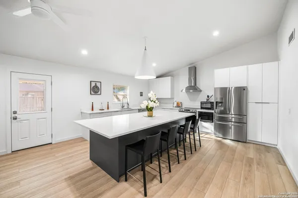 a kitchen with kitchen island a sink counter top space stainless steel appliances and cabinets