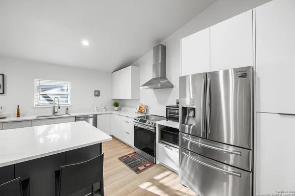 a kitchen with stainless steel appliances a refrigerator sink and stove