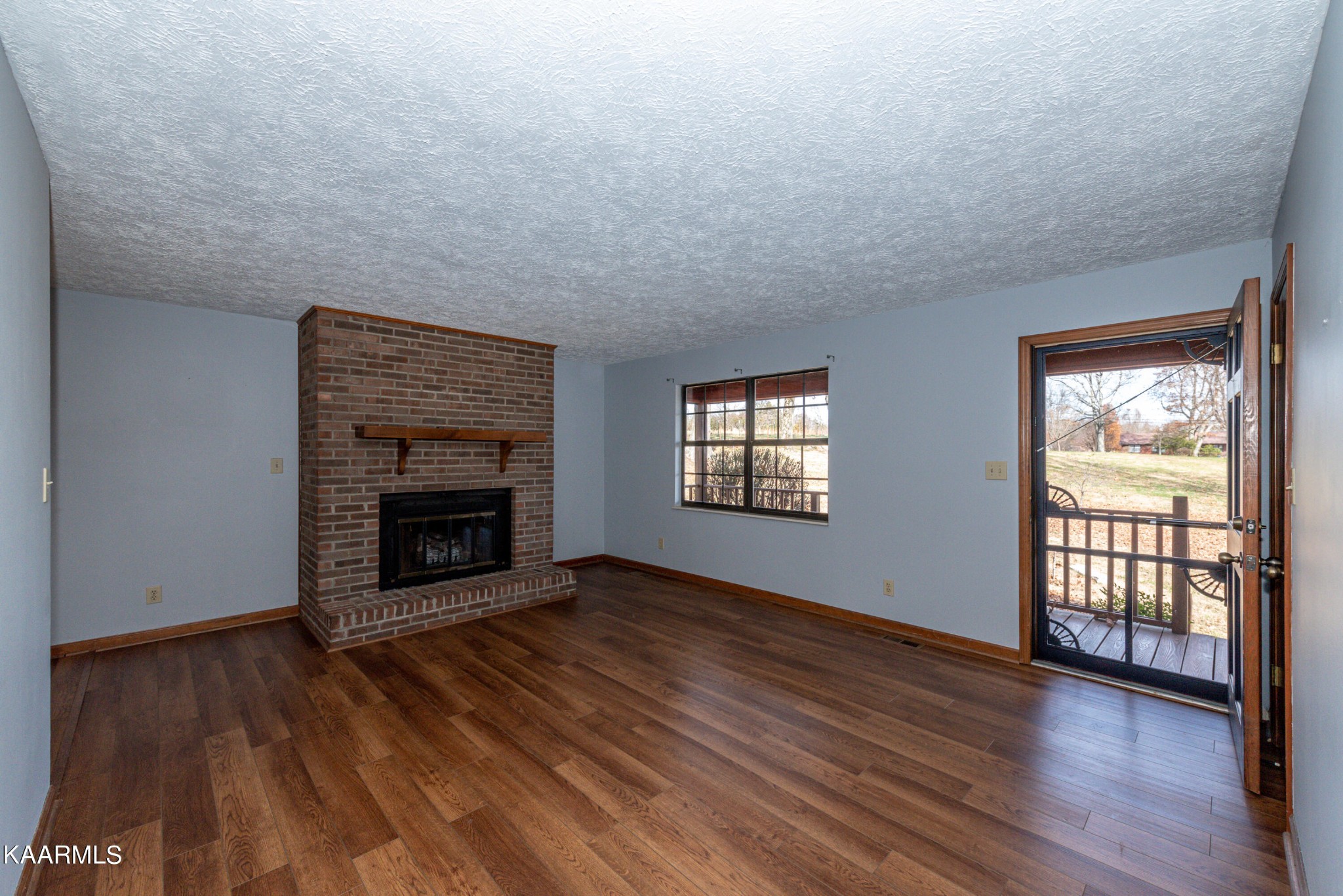 913 Mt Lebanon Road Maryville, TN 37804 - Photo 7 of 33 an empty room with wooden floor fireplace and windows