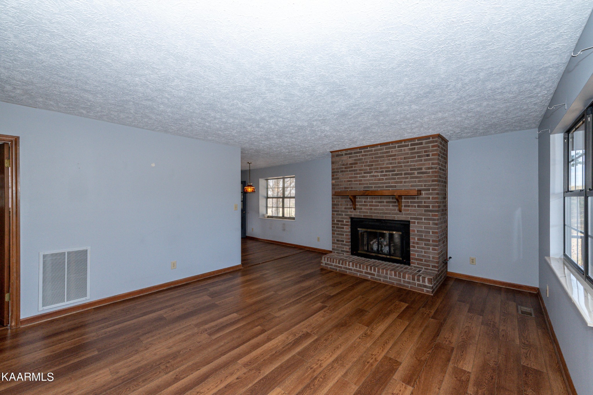 913 Mt Lebanon Road Maryville, TN 37804 - Photo 9 of 33 a view of an empty room with wooden floor fireplace and a window