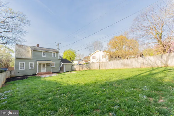 an empty room with wooden floor fireplace and windows