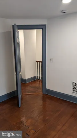 an empty room with wooden floor and a window