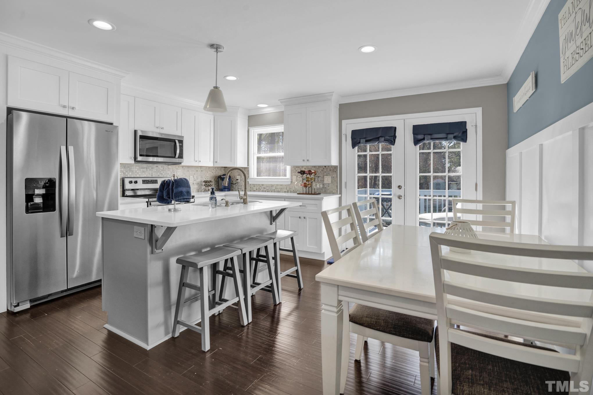 4208 Traders Dock Court Raleigh, NC 27616 - Photo 9 of 9 a kitchen with stainless steel appliances granite countertop a stove a refrigerator a sink a dining table and chairs