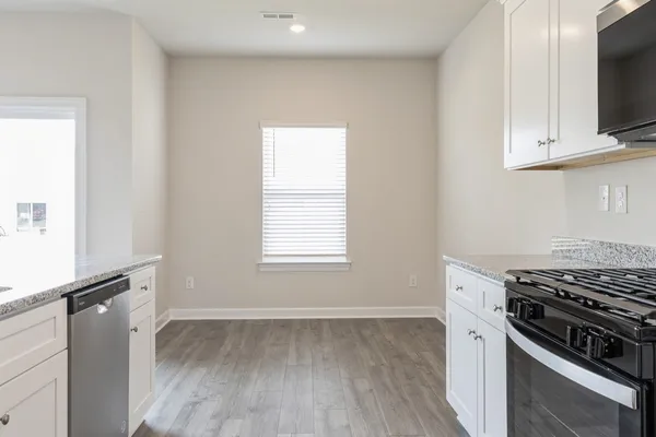 a kitchen with granite countertop a stove and a refrigerator