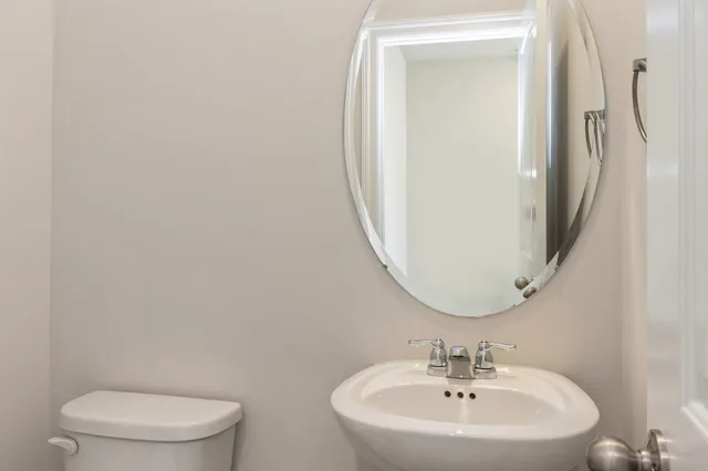 a white toilet sitting next to a bathroom sink