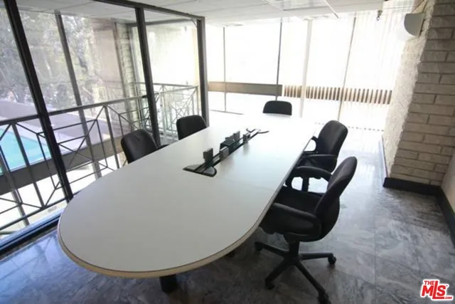 a dining room with furniture and a floor to ceiling window