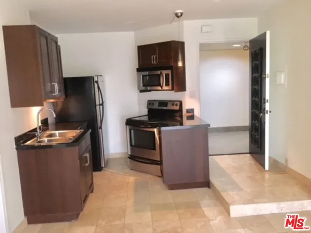 a kitchen with stainless steel appliances granite countertop a refrigerator stove and microwave