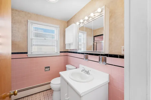 a bathroom with a toilet sink and mirror