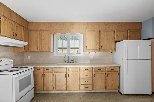 a kitchen with cabinets appliances a sink and a counter space