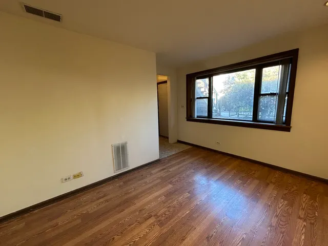 a view of a room with wooden floor and window