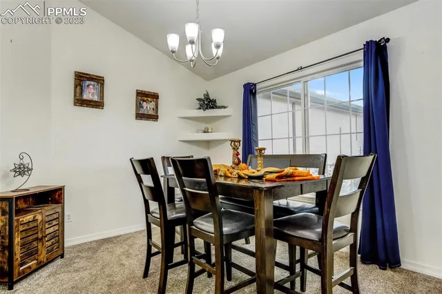 a view of a dining room with furniture wooden floor and chandelier