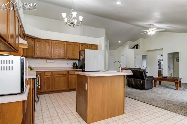 a kitchen with kitchen island a counter top space a sink stainless steel appliances and cabinets