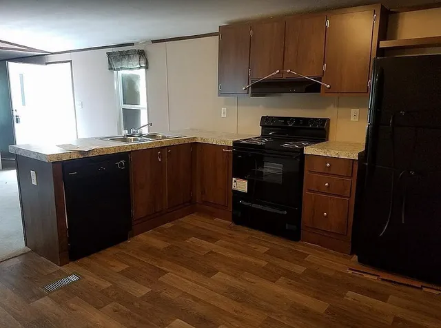 a kitchen with stainless steel appliances granite countertop a stove a refrigerator and a sink