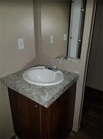 a bathroom with a granite countertop sink and a mirror