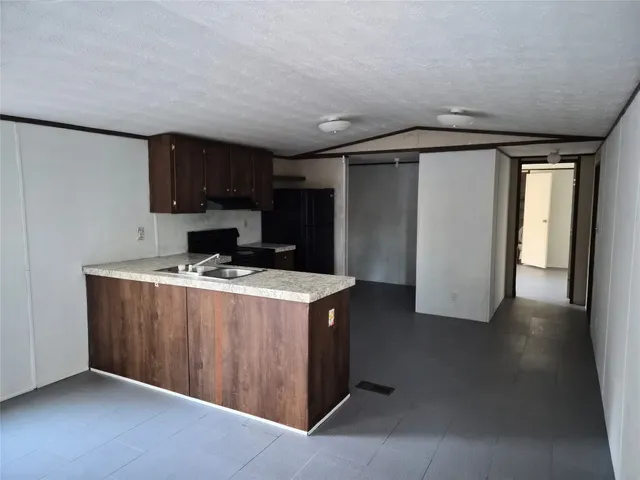 a kitchen with stainless steel appliances granite countertop a refrigerator and a stove top oven