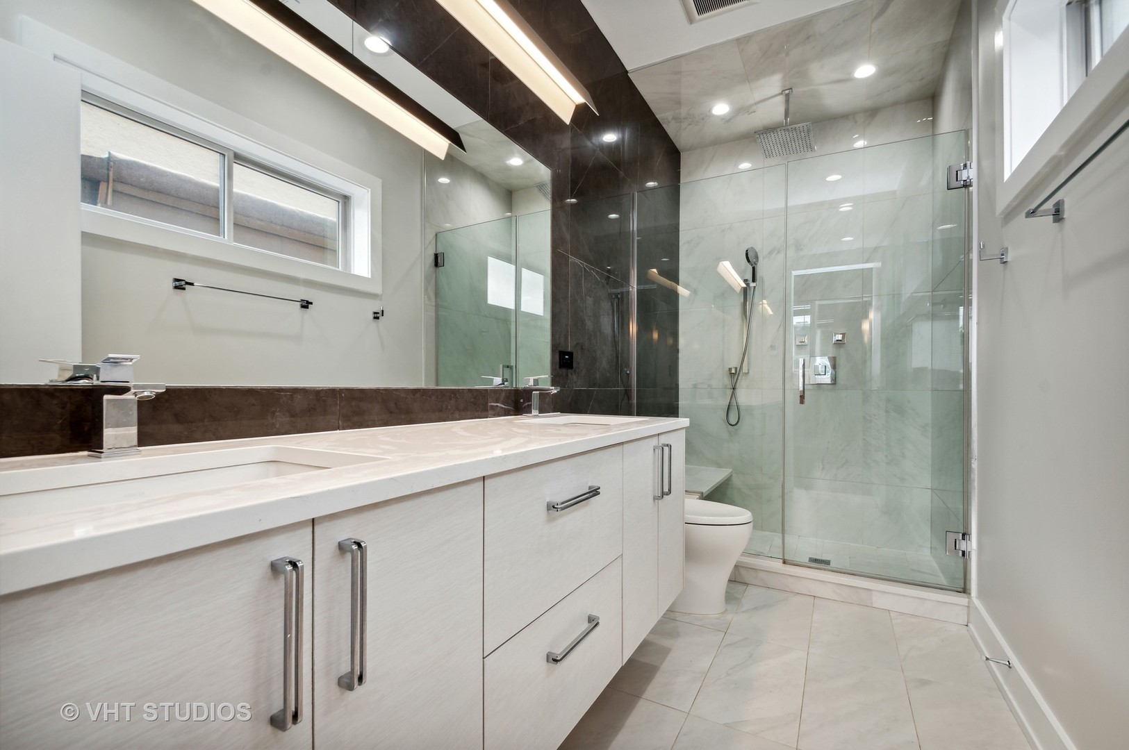 1741 West Roscoe Street, Unit 2 Chicago, IL 60657 - Photo 17 of 24 a spacious bathroom with a shower sink and mirror