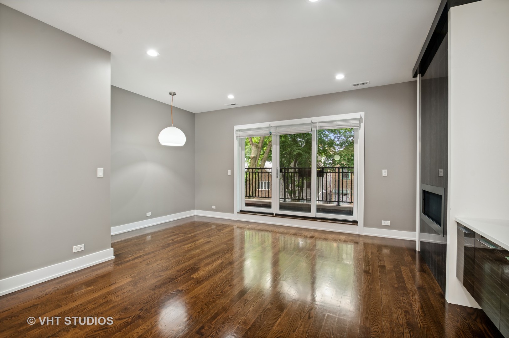 1741 West Roscoe Street, Unit 2 Chicago, IL 60657 - Photo 3 of 24 a view of an empty room with wooden floor and a window