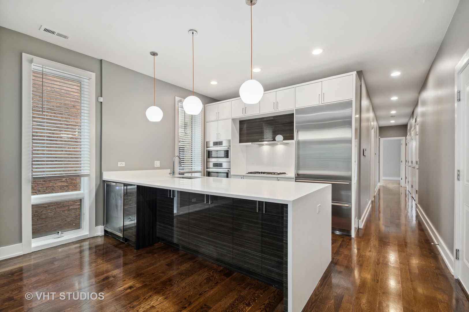 1741 West Roscoe Street, Unit 2 Chicago, IL 60657 - Photo 8 of 24 a large kitchen with a counter space a sink stainless steel appliances and cabinets