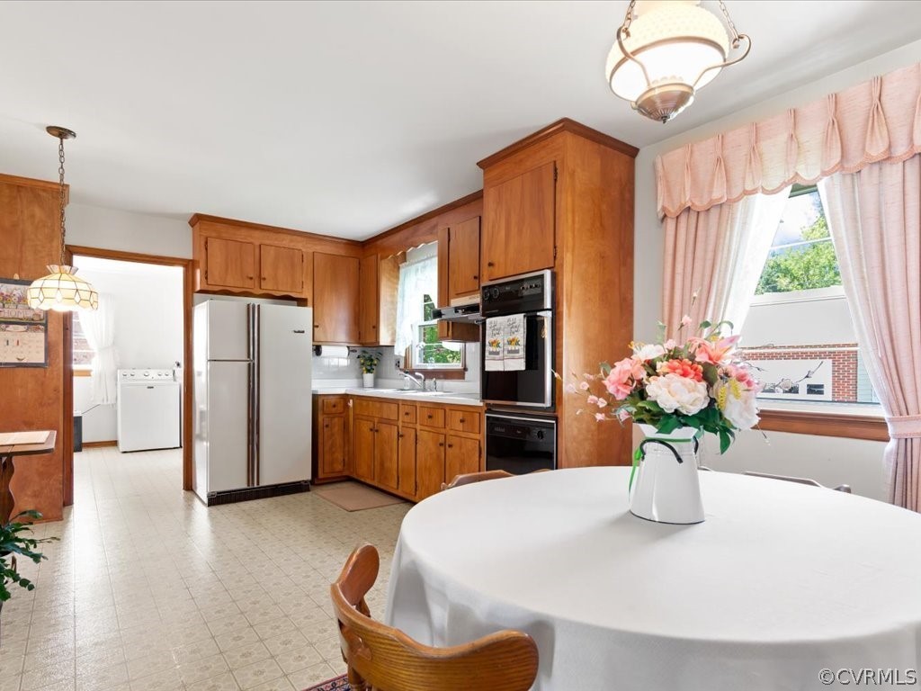 6401 Commander Road Richmond, VA 23224 - Photo 12 of 19 a kitchen with stainless steel appliances a refrigerator a sink a microwave a dining table and chairs