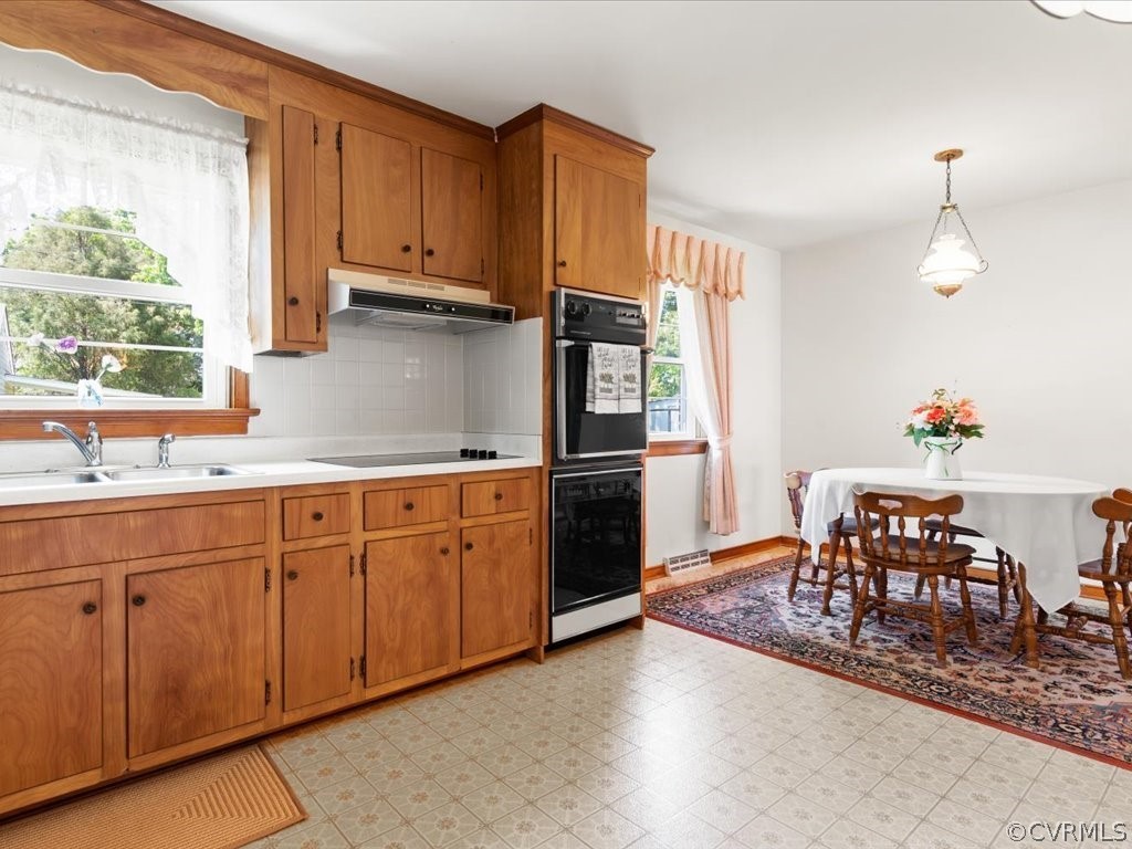 6401 Commander Road Richmond, VA 23224 - Photo 13 of 19 a kitchen with granite countertop a refrigerator stove top oven dining table and chairs
