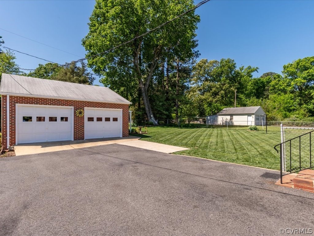 6401 Commander Road Richmond, VA 23224 - Photo 3 of 19 a view of a house with a yard and garage