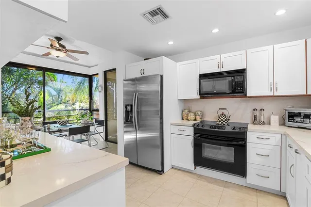 a kitchen with stainless steel appliances a stove a sink a refrigerator a stove a microwave and cabinets