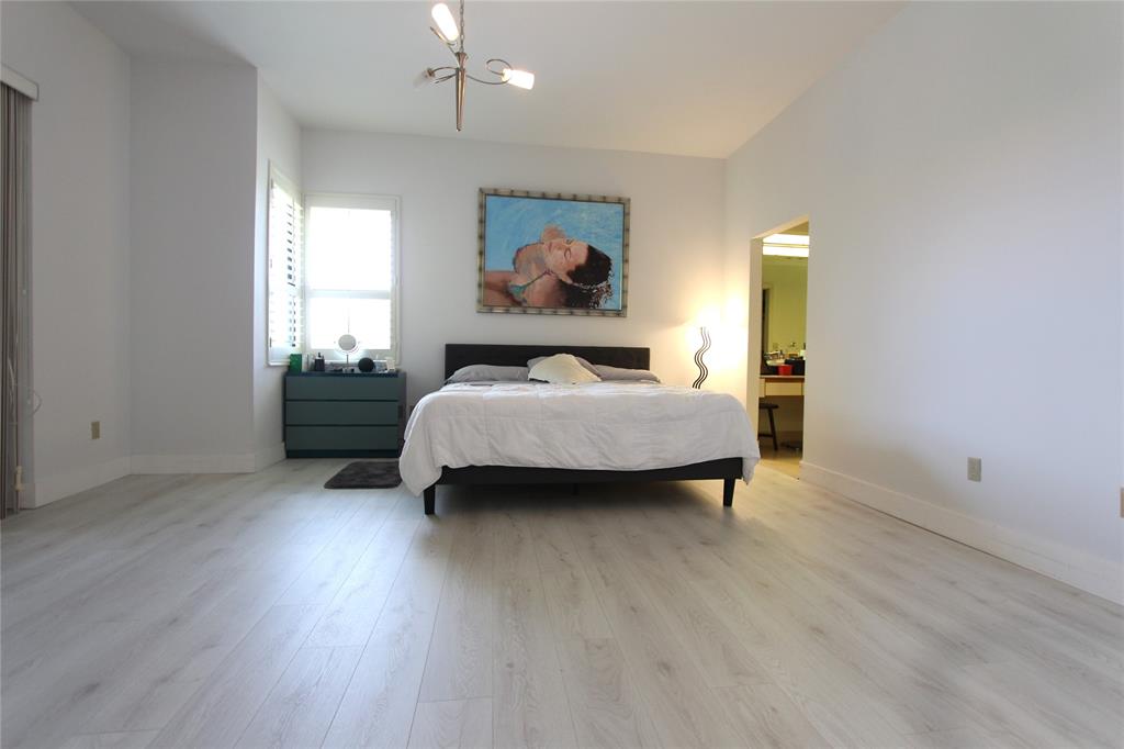 7535 La Paz Boulevard, Unit 301 Boca Raton, FL 33433 - Photo 15 of 42 a bedroom with a bed and wooden floor