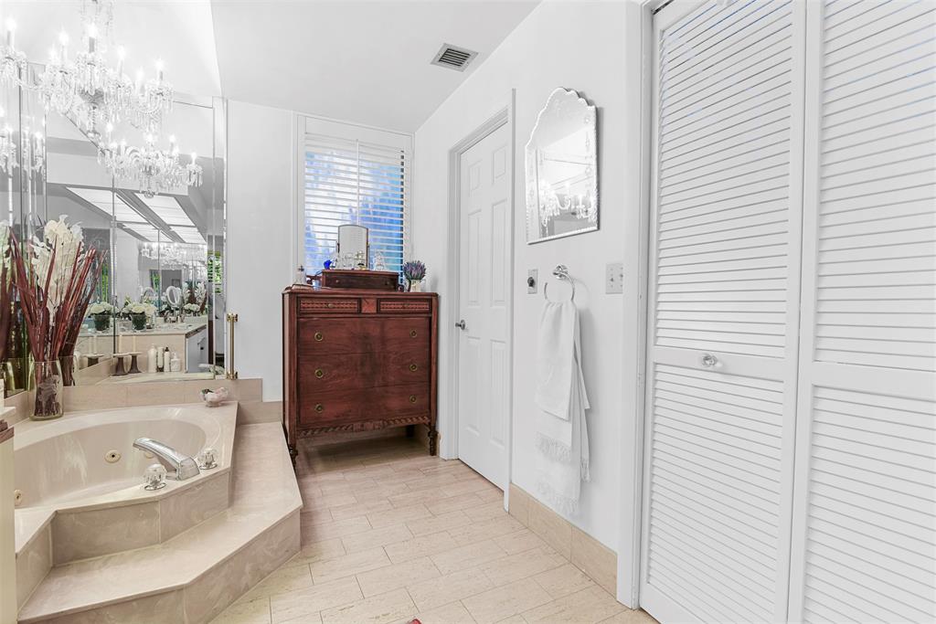 7535 La Paz Boulevard, Unit 301 Boca Raton, FL 33433 - Photo 19 of 42 a bathroom with a tub sink and mirror