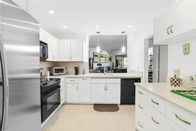 a kitchen with white cabinets stainless steel appliances and sink