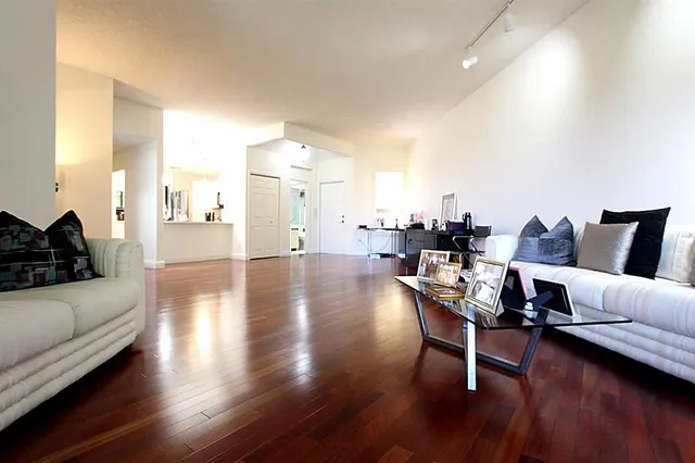 a spacious bedroom with a bed and a large mirror with a chandelier